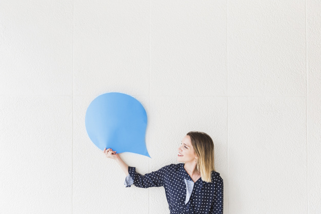 happy woman looking at blue speech bubble paper